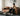 Man sitting on an M1 Sofa in a living room, with a coffee table in front of it.